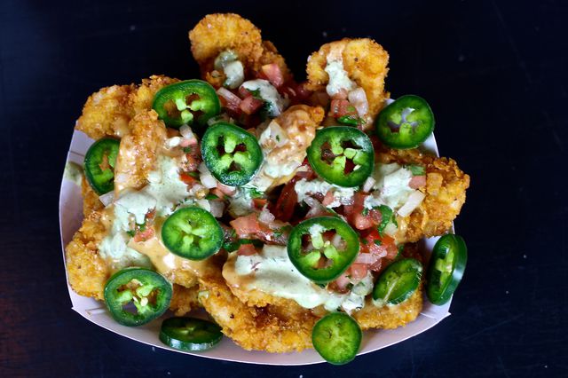 Nugchos: Tenderized chicken breast coated in corn tortillas, deep fried and smothered with pico de gallo, nacho queso, O.G. Ranch and jalapenos<br>